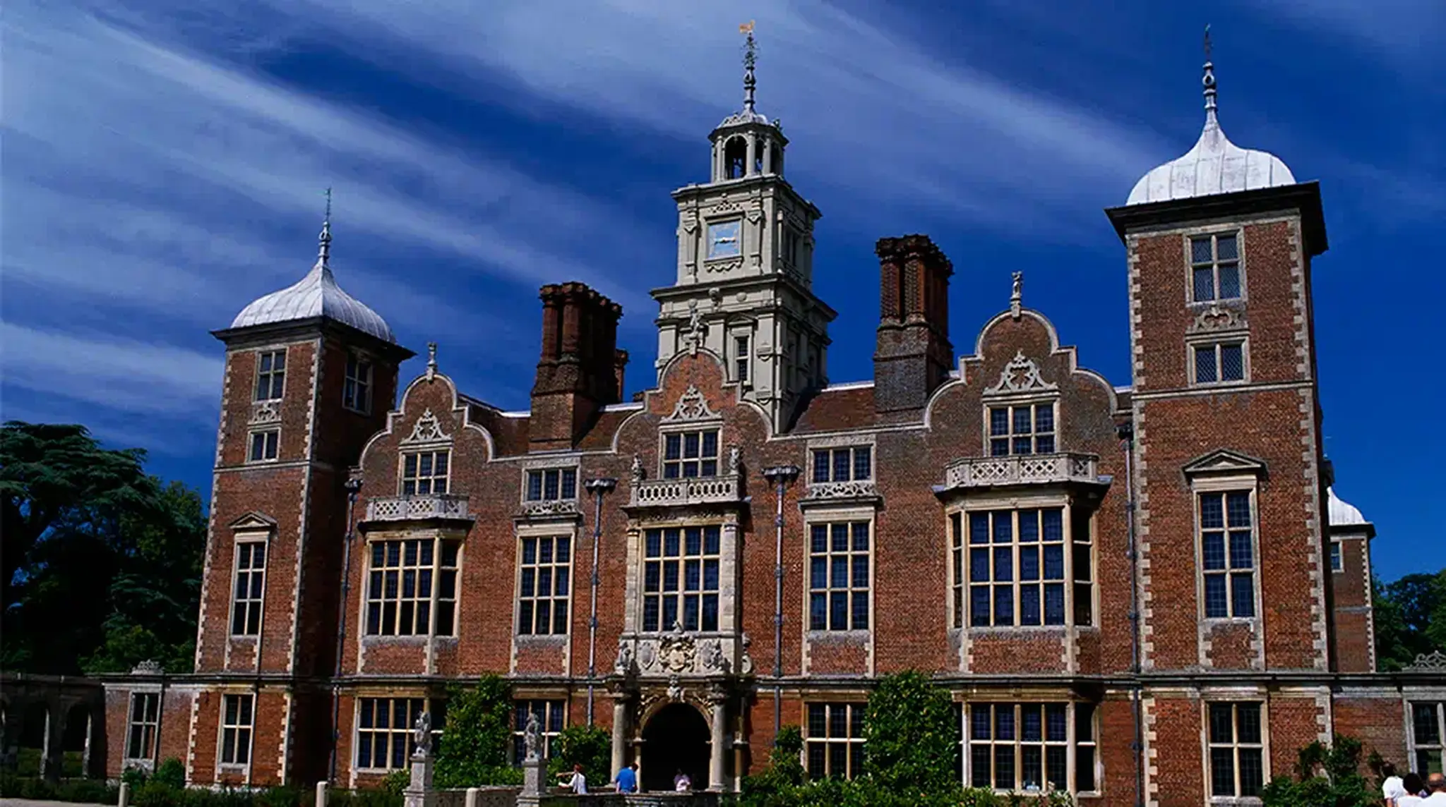 Historic brick mansion with tall windows, ornate details, and clock tower