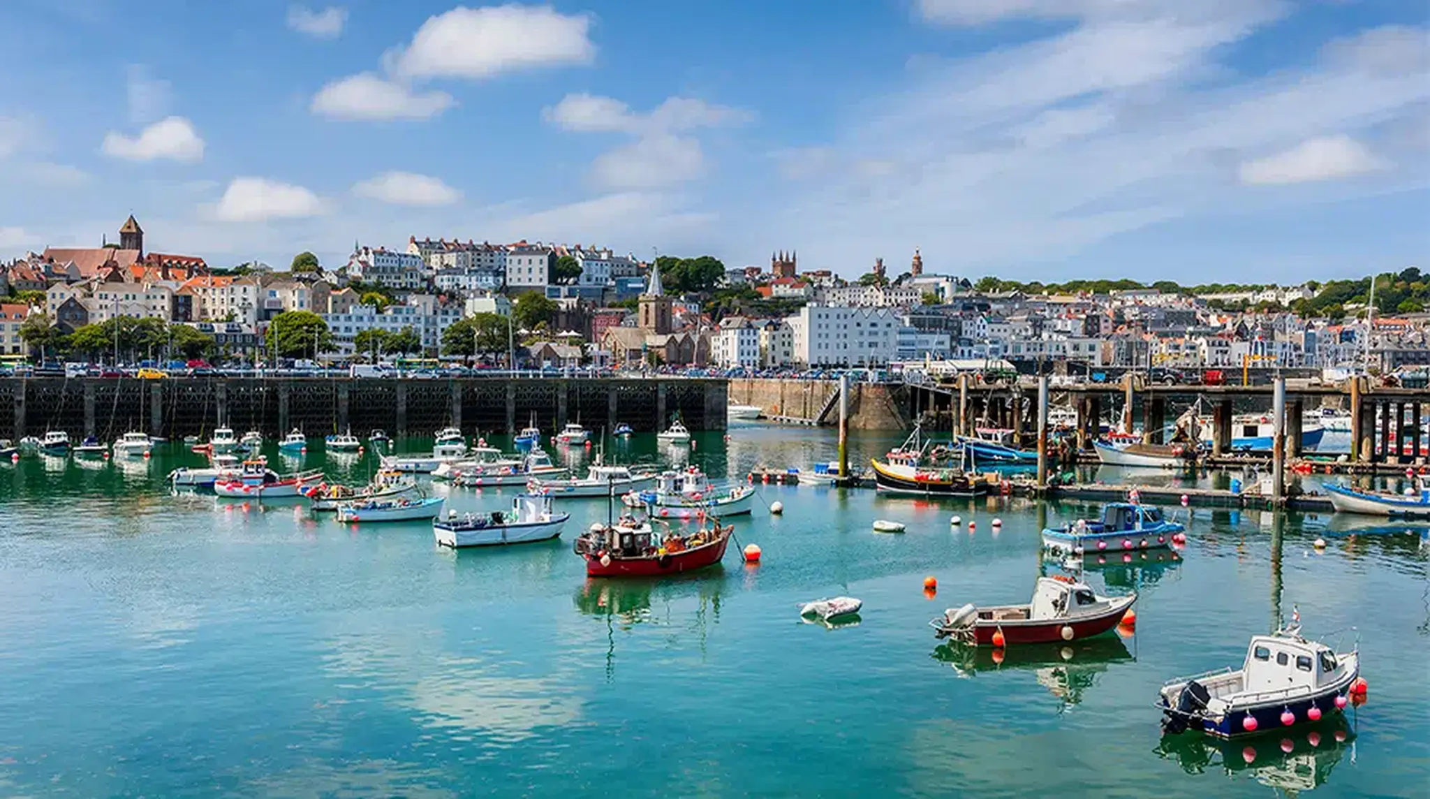 Boats floating in a vibrant harbour with coloUrful buildings