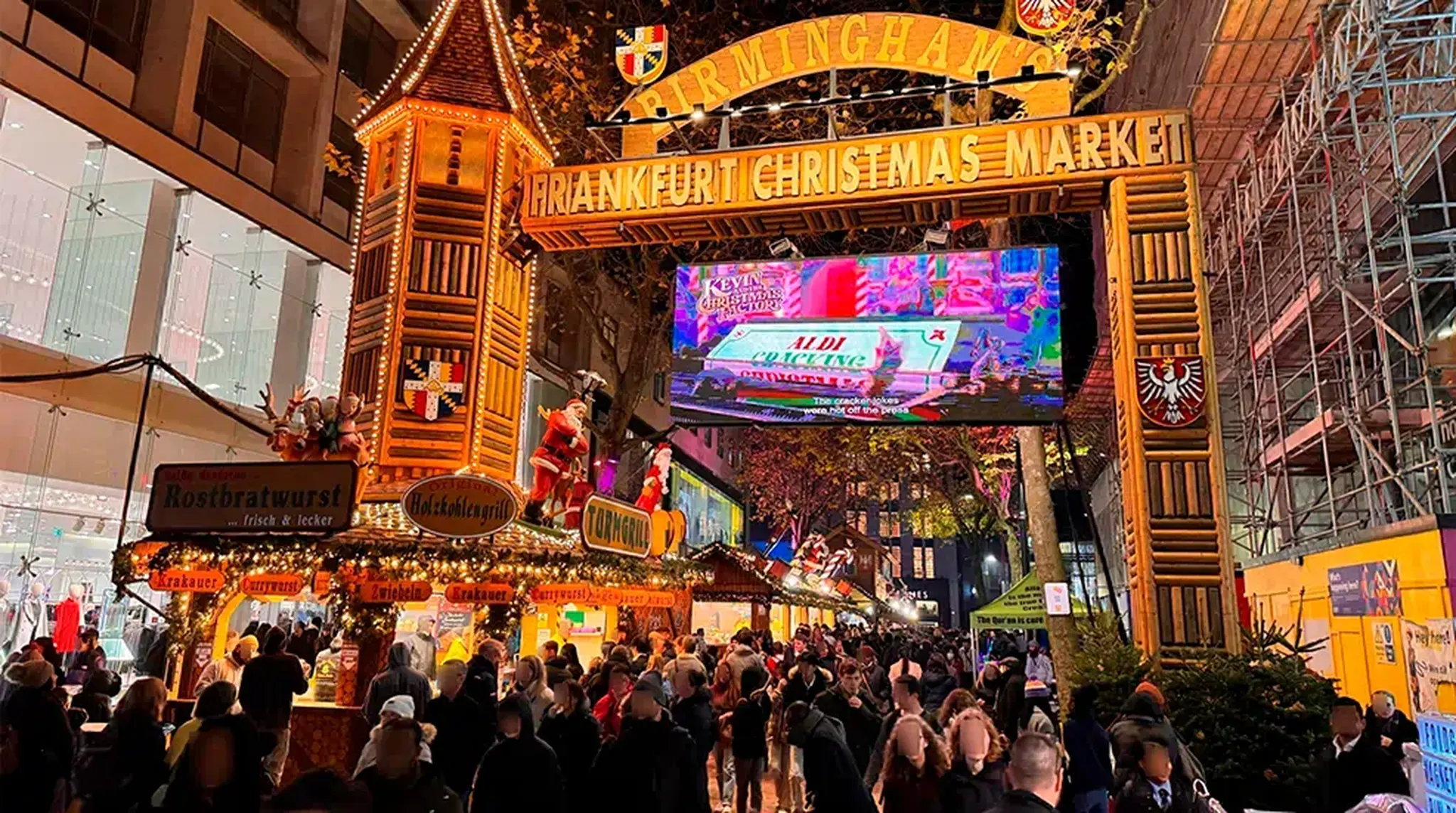 Crowded Frankfurt Christmas Market entrance at night, with festive booths