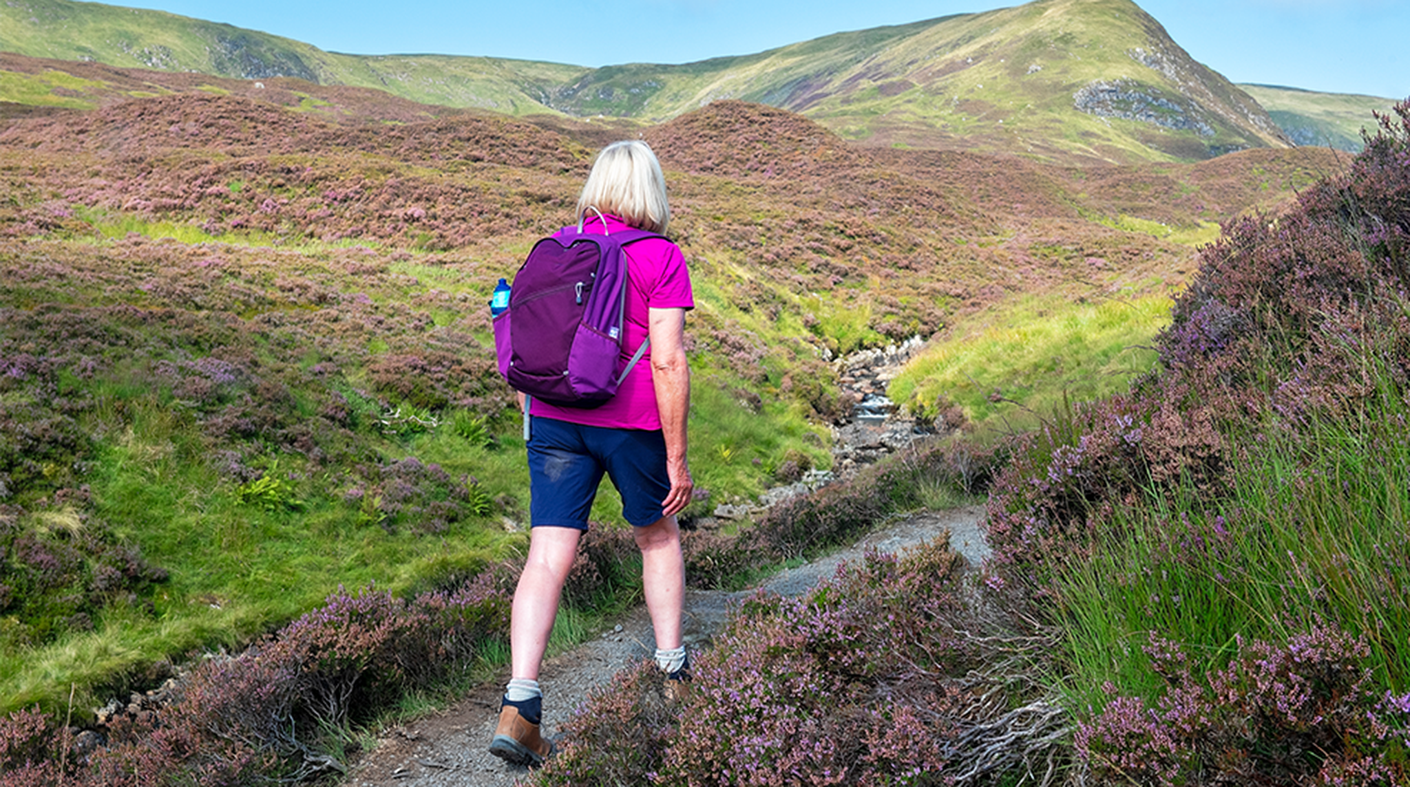 One senior female hiking on the Grey Mare’s Tail Waterfall trail near Moffatt in Scotland.