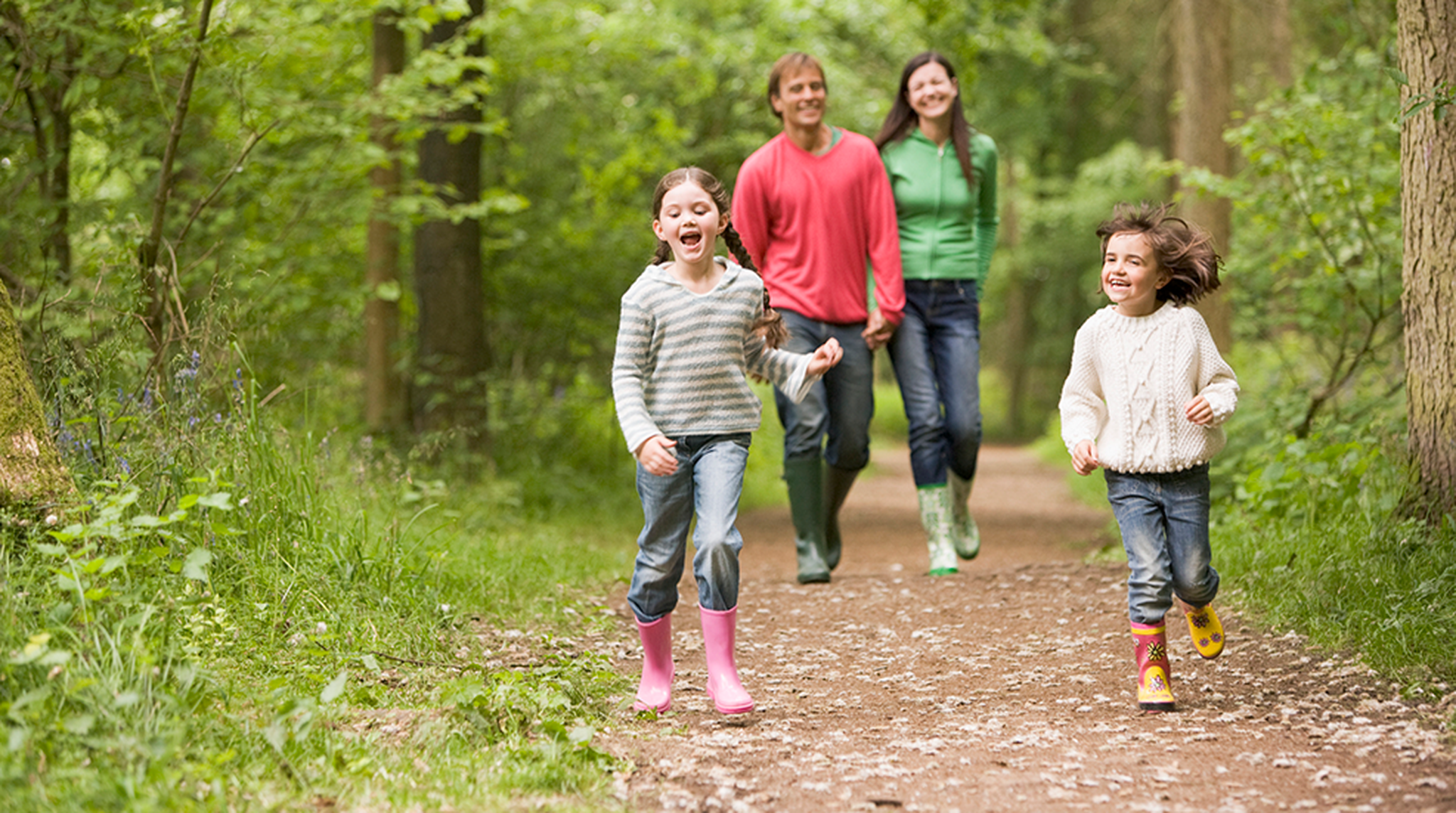 Happy family walking on a path in the woods