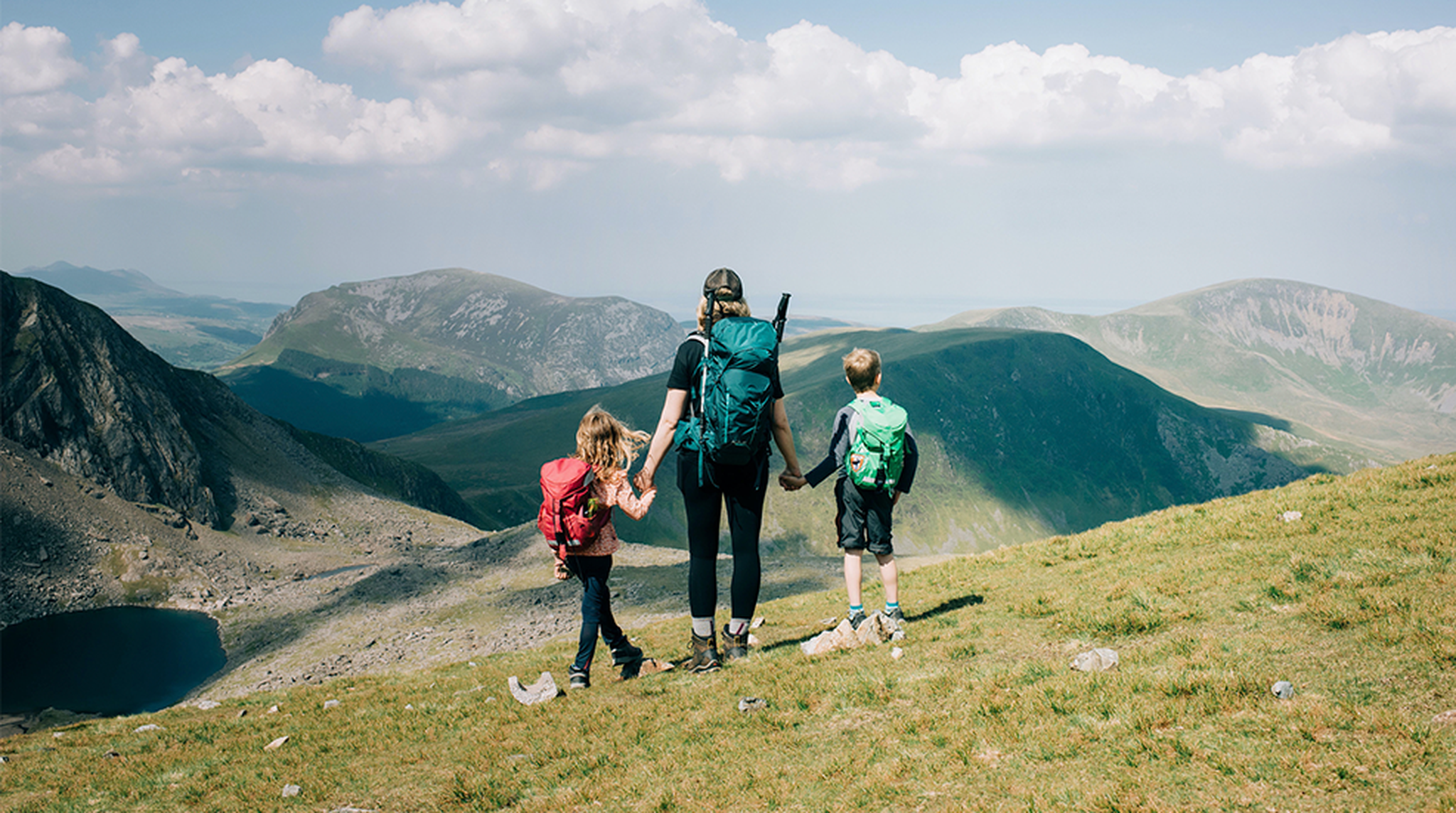 Mother and children with their backs to the camera overlooking the view of Mount Snowdon