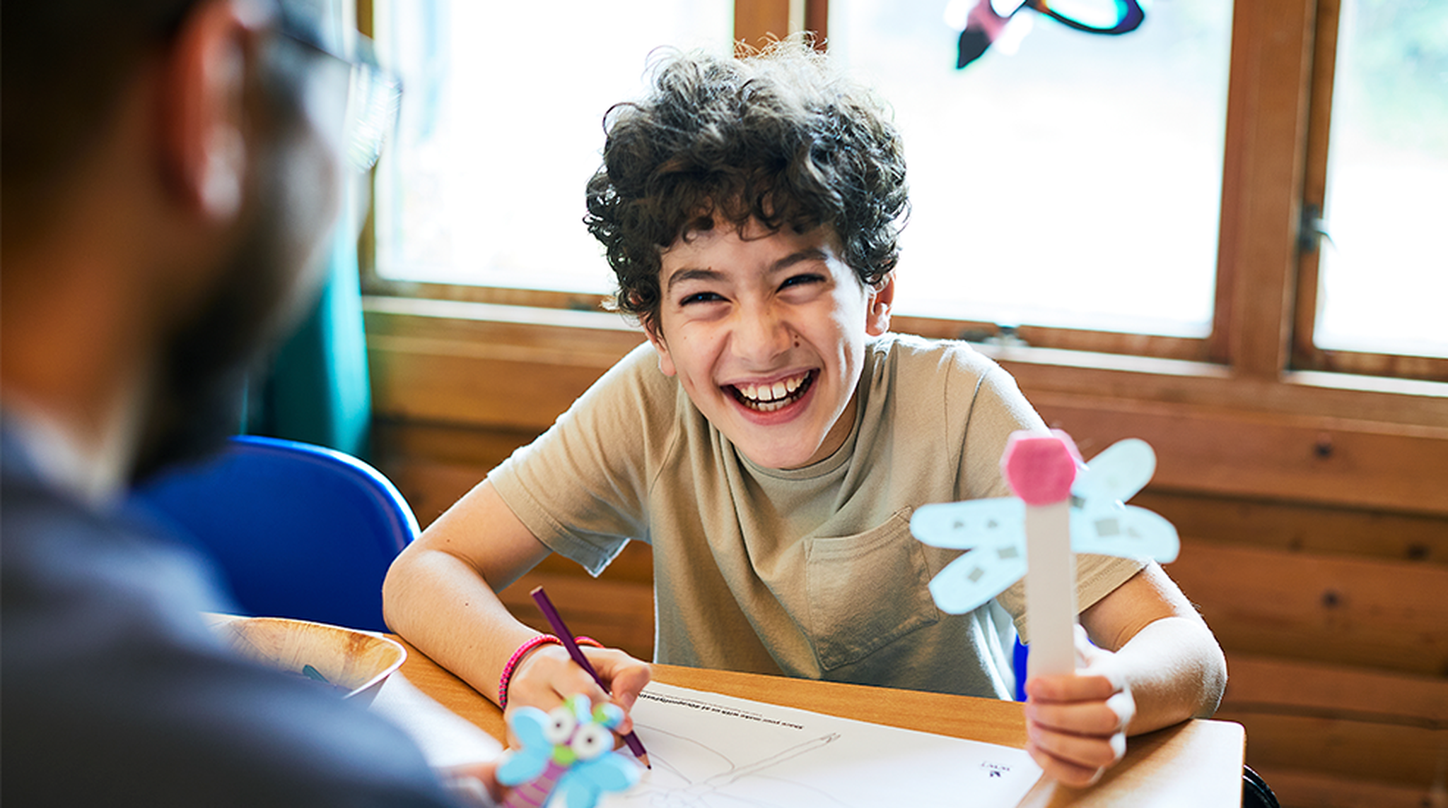 Boy looking happy creating crafts at WWT Dragonfly Festival