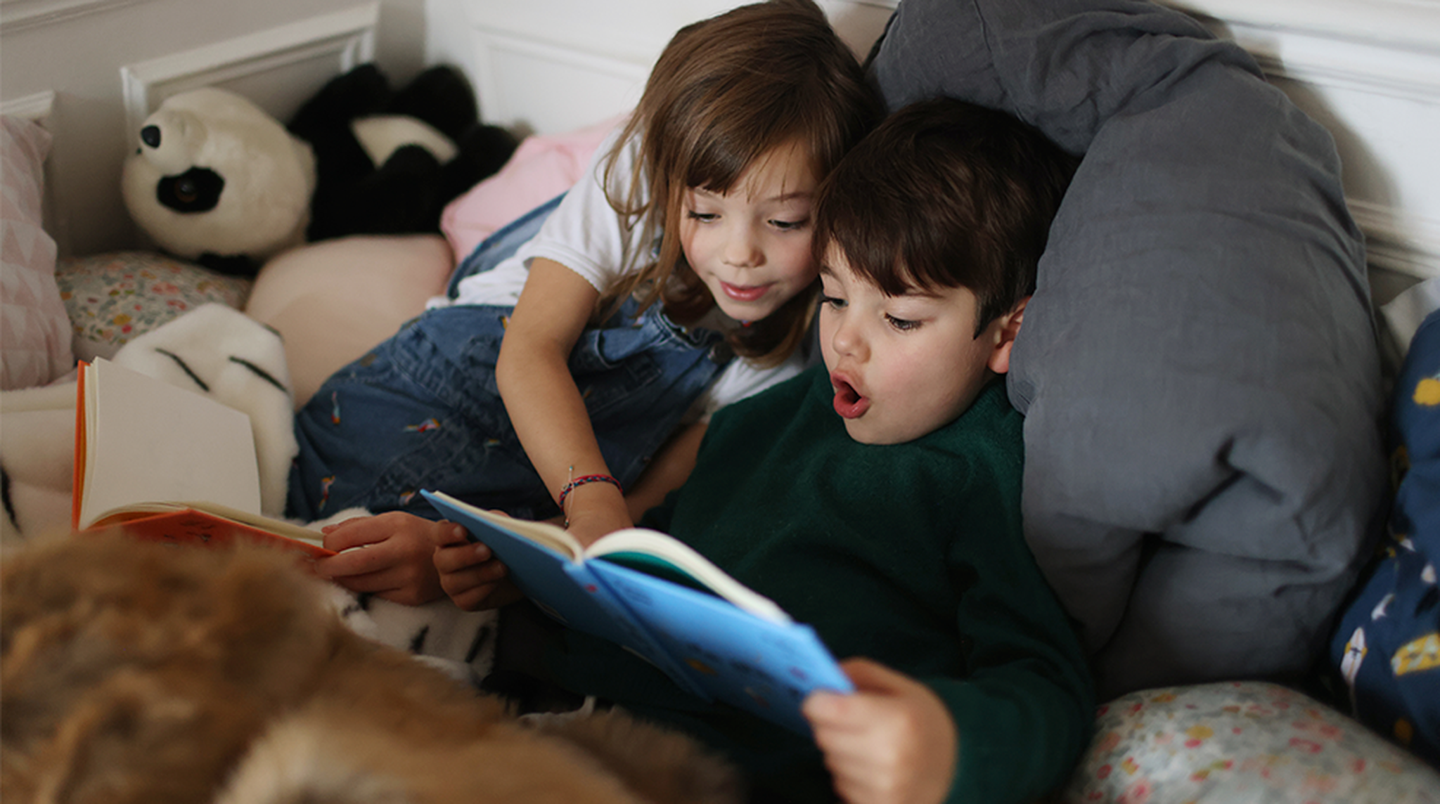 Two children reading a book together