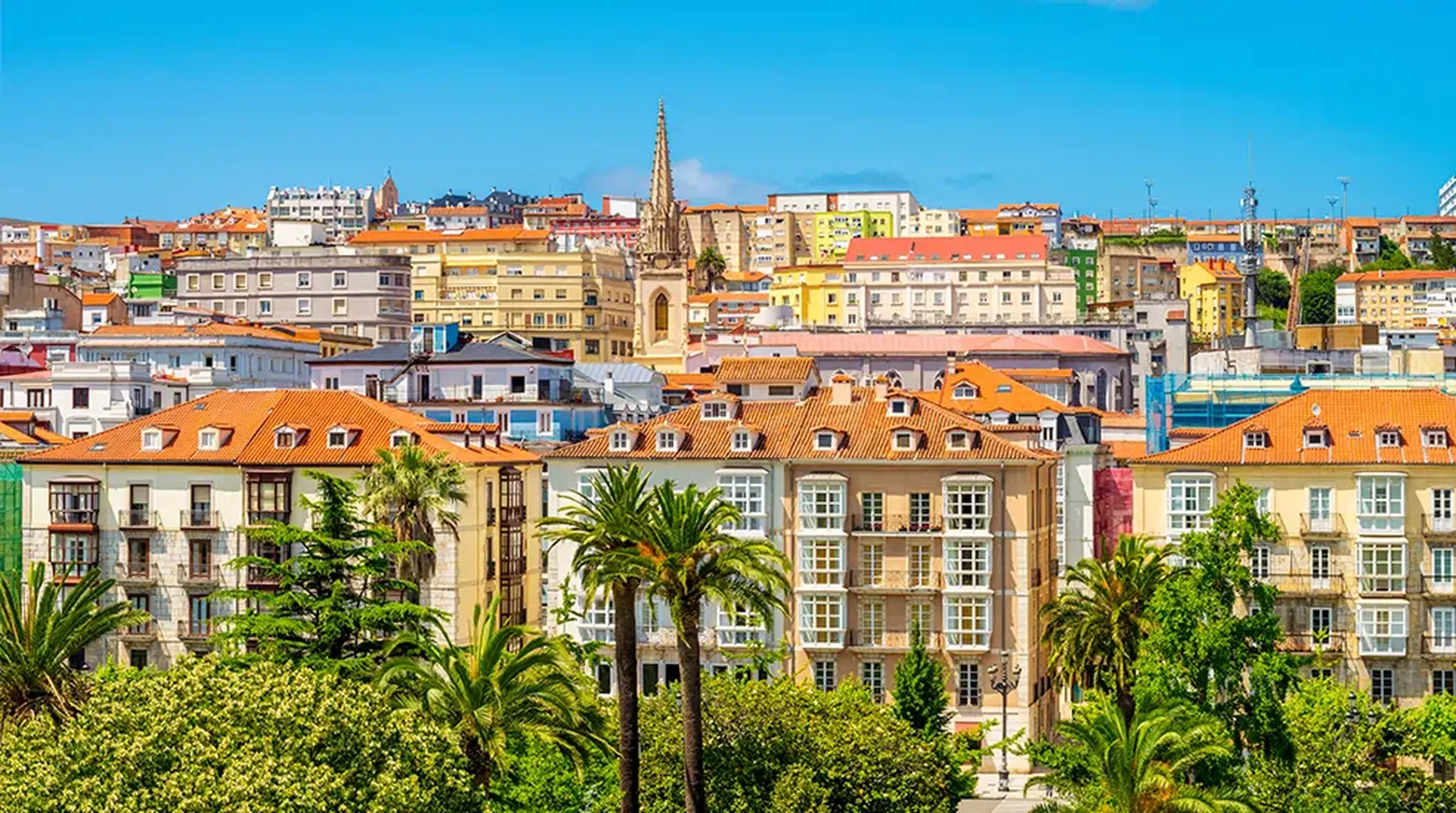 A vibrant cityscape featuring colourful buildings with red-tiled roofs