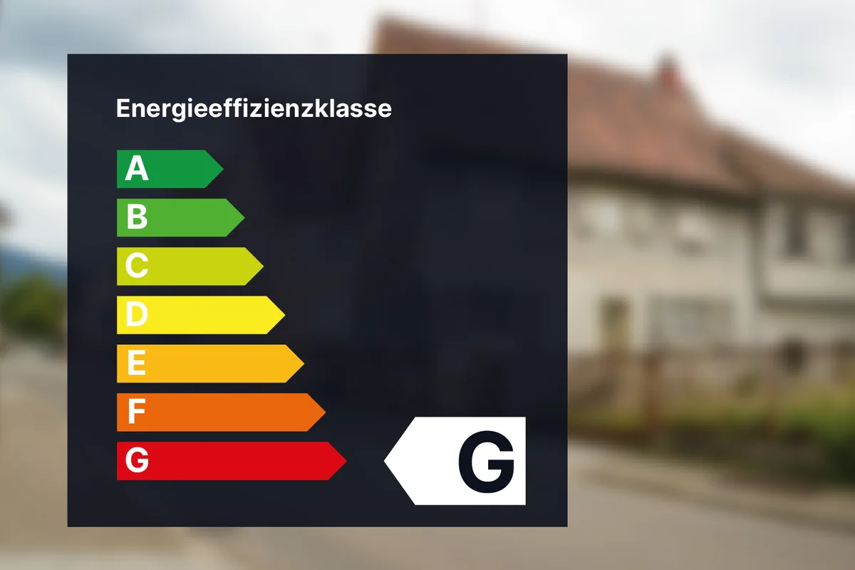 Energieeffizienz-Bewertungstabelle mit den Kategorien A bis G, G hervorgehoben. Unscharfer Hintergrund eines Vorstadthauses und einer Straße.