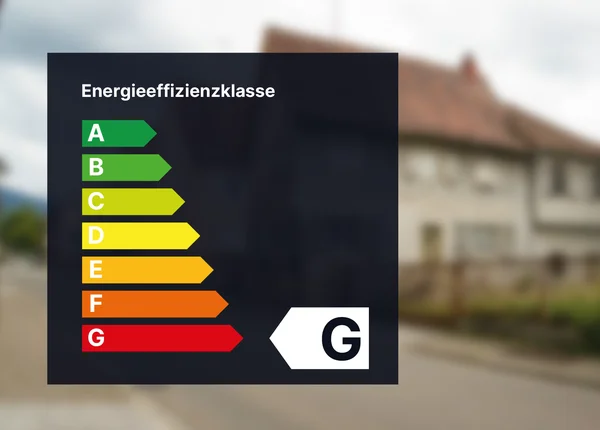 Energieeffizienz-Bewertungstabelle mit den Kategorien A bis G, G hervorgehoben. Unscharfer Hintergrund eines Vorstadthauses und einer Straße.