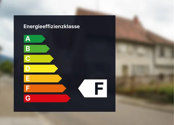 Energieeffizienz-Bewertungstabelle mit den Kategorien A bis G, wobei Klasse F hervorgehoben ist. Unscharfer Hintergrund eines Wohngebäudes.