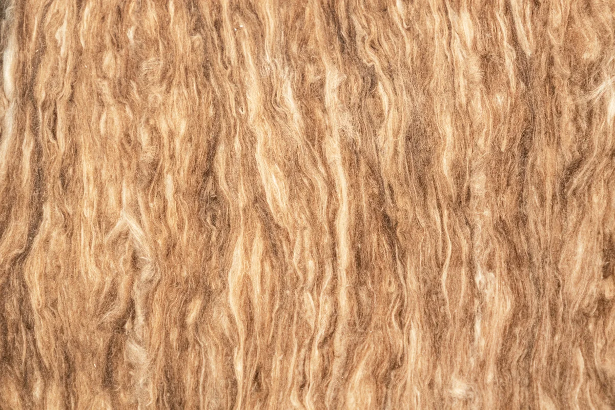 Detailaufnahme von brauner Holzfaser-Dämmung mit natürlicher, faseriger Struktur – umweltfreundliches Dämmmaterial für nachhaltiges Bauen und energetische Sanierung.