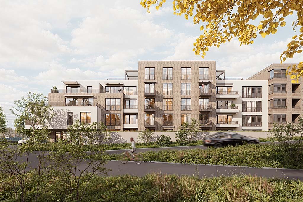 Moderní bytový dům s velkými okny a balkóny, obklopený zelení.