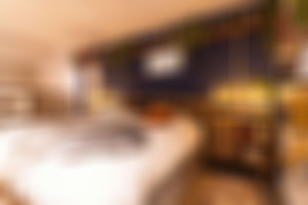 Das Bild zeigt ein gemütliches Schlafzimmer mit dunkler Wand.