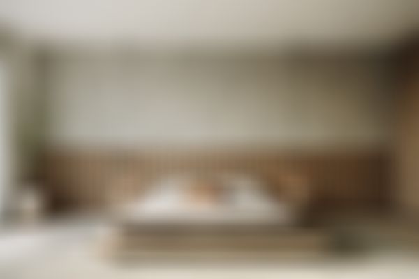 Minimalistisches Schlafzimmer mit einem niedrigen Holzplattformbett, grauer Bettwäsche, Holzvertäfelung, Hängelampen, einer Topfpflanze und einem großen Fenster.