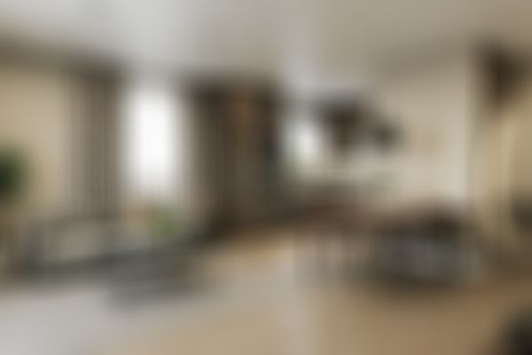 Moderner Wohn-Essbereich mit Küche in offener Gestaltung mit einem gemütlichen Sofa, einem Esstisch, eleganten Schränken und einem großen Fenster mit Vorhängen. Durchgehend in neutralen Farbtönen gehalten.