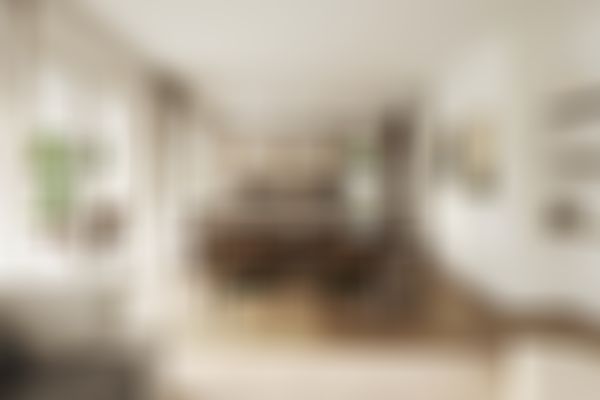 Moderner, offener Ess- und Küchenbereich mit Holzböden, Pendelleuchten, großen Fenstern und Blick auf die Terrasse. Gemütliches und minimalistisches Design.