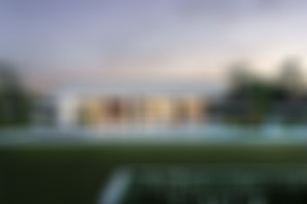 Ein moderner Bungalow mit großen Fenstern, einem Swimmingpool mit Liegestühlen in einem gepflegten Garten bei Einbruch der Dämmerung.