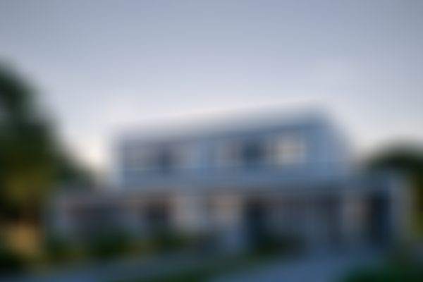 Modernes zweigeschossiges weißes Haus mit großen Fenstern, umgeben von Bäumen und Sträuchern, unter einem Himmel am frühen Abend.