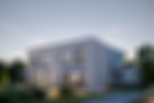 Modernes zweigeschossiges weißes Haus mit großen Fenstern, Sonnenschirmen auf der Terrasse und umgebendem Grün unter einem Himmel in der Dämmerung.