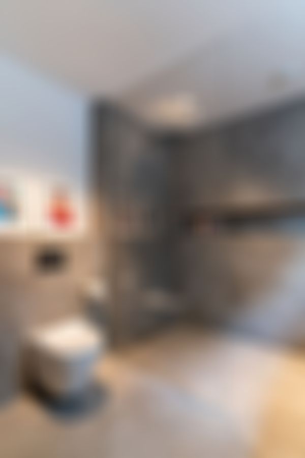 Das Bild zeigt das Kinderbad welches mit großformatigen grauen Fliesen ausgestattet ist.