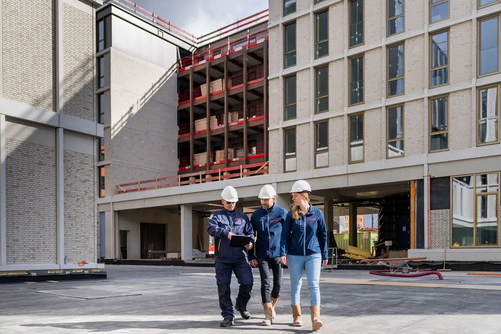Overleg van collega's op bouwplaats op tablet kijkend Avans Hogeschool