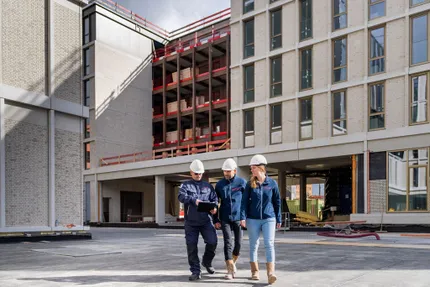 Overleg van collega's op bouwplaats op tablet kijkend Avans Hogeschool