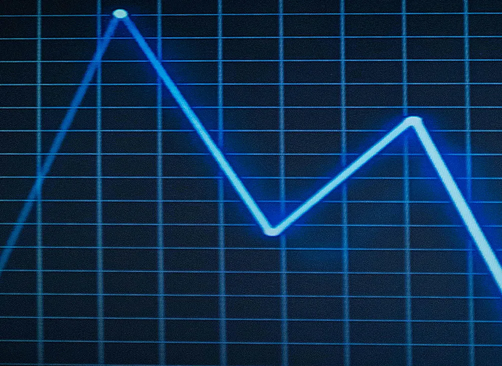 Een grafiek in neonblauw die in het begin omhoog gaat en daarna naar beneden