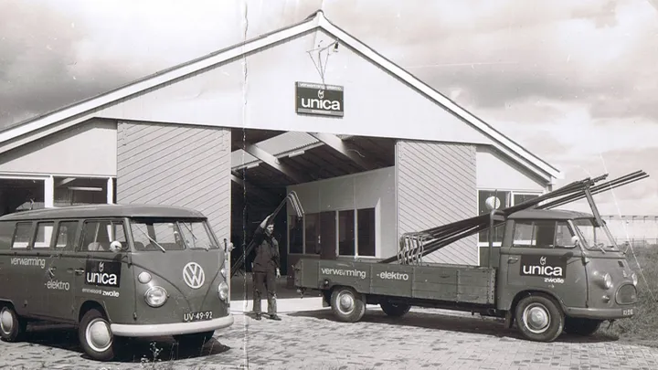 Historische foto van Unica vestiging met een Volkswagen busje en pickup beide met oud Unica logo