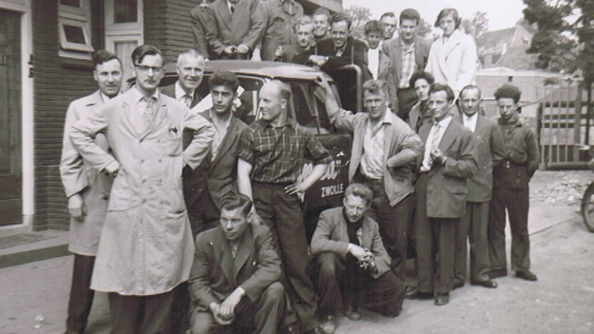 Historische foto uit1956 met twintig mannen die om de eerste Tempo vrachtwagen van Unica aan de Brink in Zwolle staan