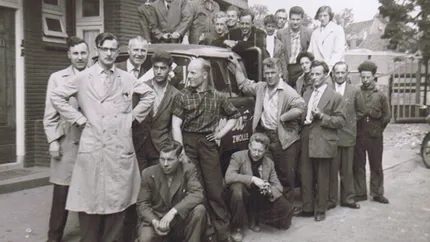Historische foto uit1956 met twintig mannen die om de eerste Tempo vrachtwagen van Unica aan de Brink in Zwolle staan