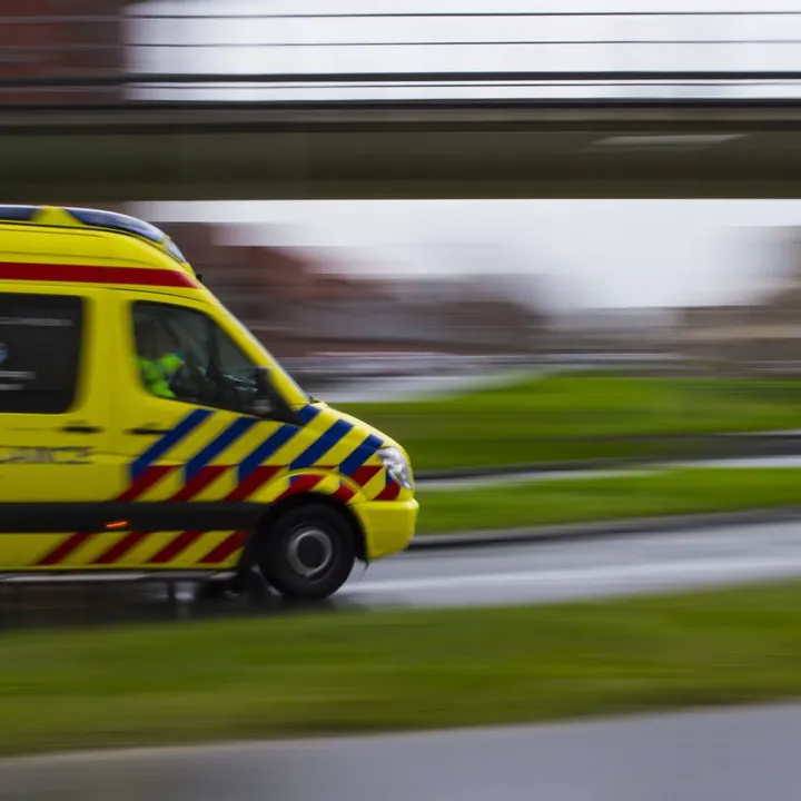 Beeld van ambulance die onder viaduct rijdt