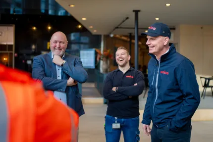 Unica CEO Jilko Andringa lachend in Unica kleding en veiligheidscap op projectbezoek bij Delftste Poort in Rotterdam