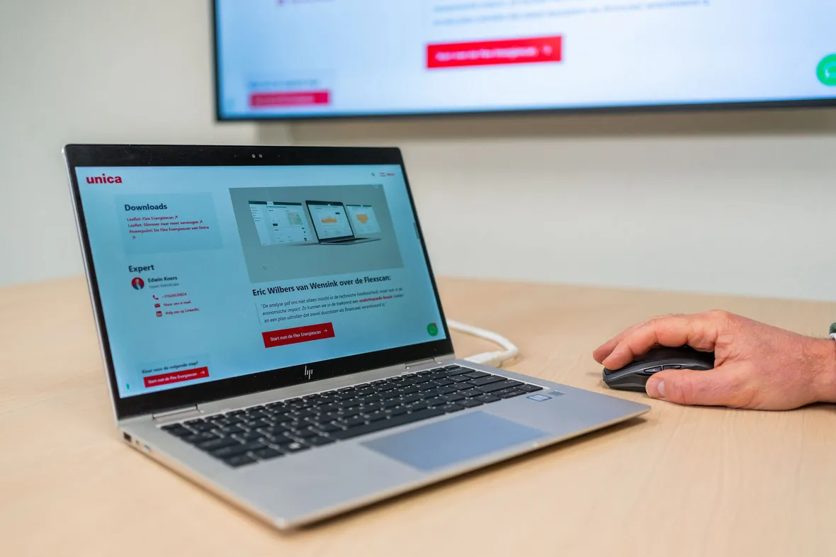 Website van Flexscan met advies over energieverbruik, subsidies (UBS) en consultancy (UES) op laptop in bespreking.