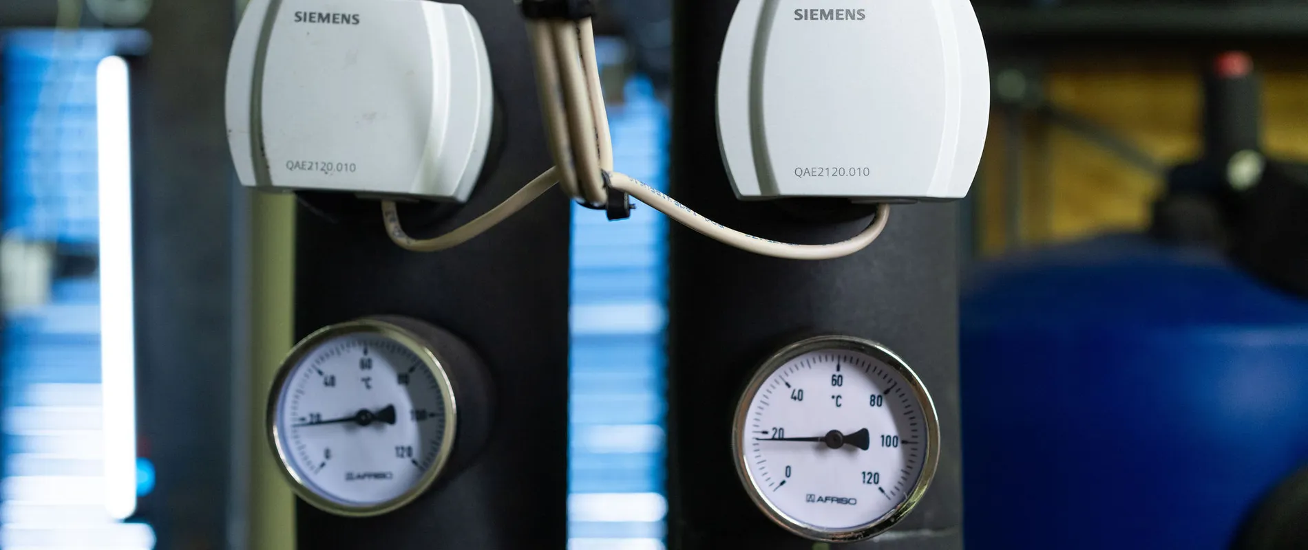 Detailopname van temperatuurmeters en sensoren in technische ruimte van een installatie.