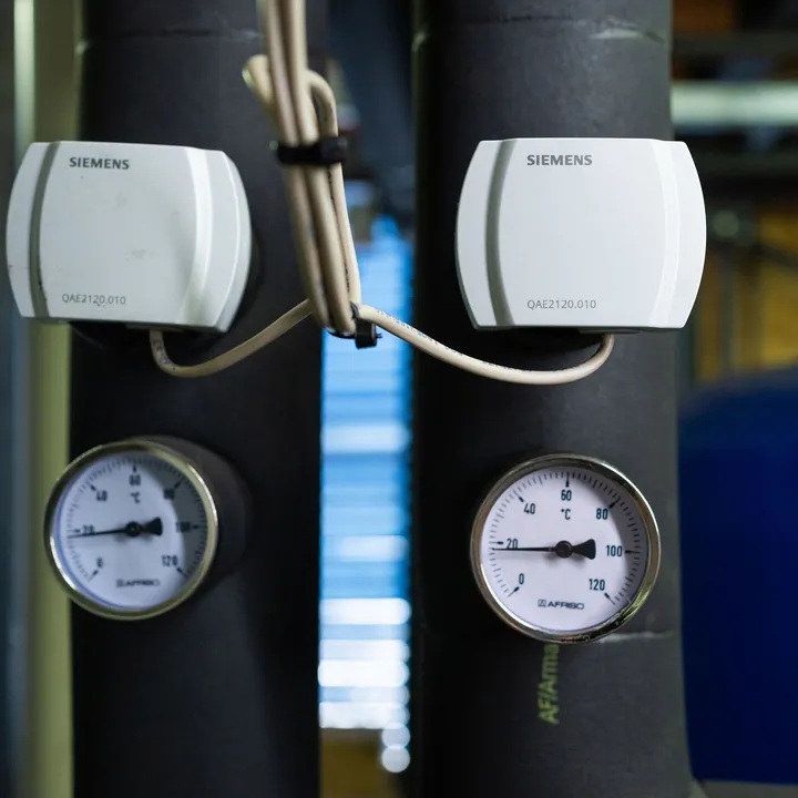 Detailopname van temperatuurmeters en sensoren in technische ruimte van een installatie.