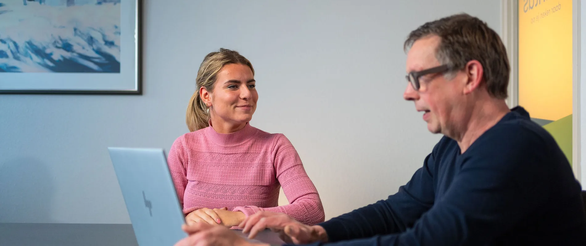 Unica-medewerker toont klant rapportage of besparingsplan in energieadviesgesprek.