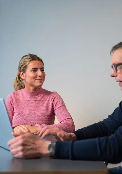 Unica-medewerker toont klant rapportage of besparingsplan in energieadviesgesprek.