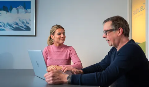 Unica-medewerker toont klant rapportage of besparingsplan in energieadviesgesprek.