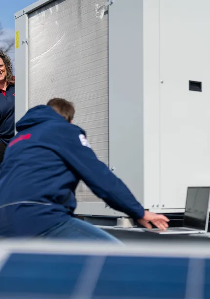 Unica-technici inspecteren een installatie op het dak met zonnepanelen voor energieprestaties en onderhoud.