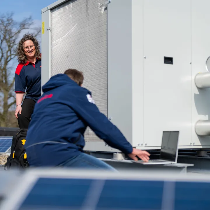 Unica-technici inspecteren een installatie op het dak met zonnepanelen voor energieprestaties en onderhoud.