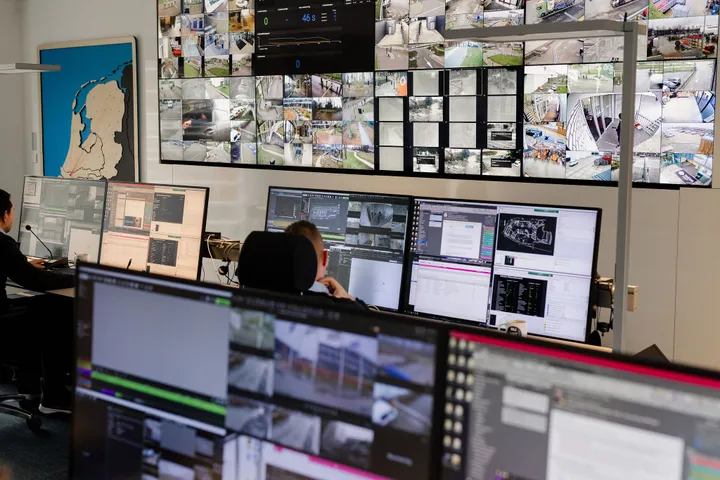 Mannen kijken naar een videowall