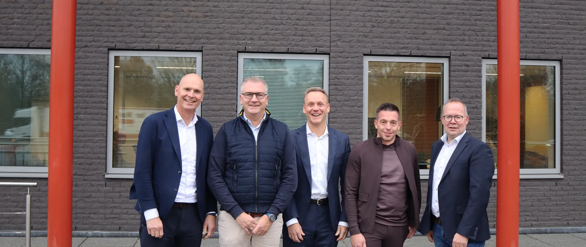 Bestuursleden van Unica en Niemeijer voor het hoofdkantoor van Unica