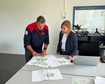 Man en vrouw kijken naar tekening met beveiligingsplan
