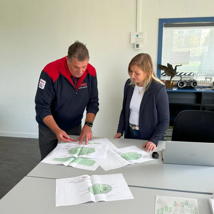Man en vrouw kijken naar tekening met beveiligingsplan