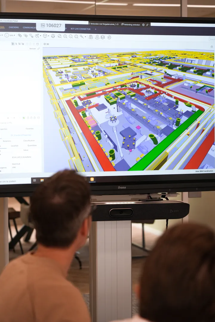 Bim coordinator kijkend naar groot vergaderscherm