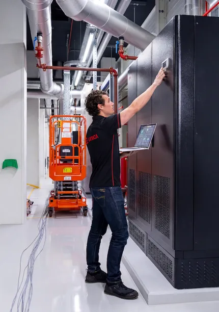 Man in de technische ruimte van een datacenter