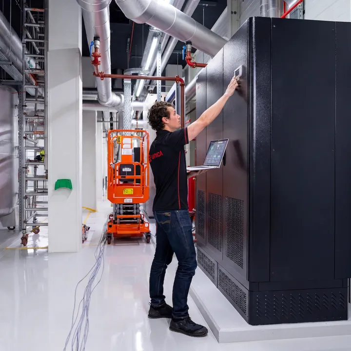 Man in de technische ruimte van een datacenter