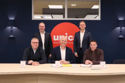 Tekenmoment Niemeijer sluit aan bij Unica, bestuursleden van Unica en Niemeijer aan tafel.