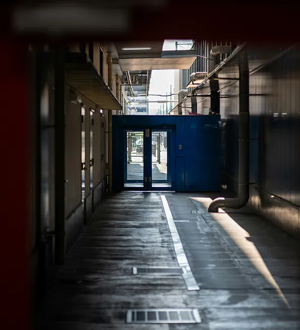 Industriële doorgang met leidingen en technische infrastructuur in een productieomgeving.