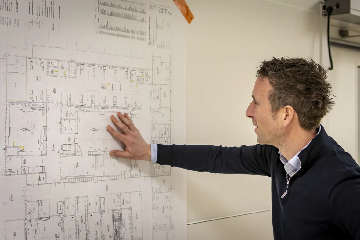 Danny van der Put, projectmanager bij Unica Building Projects kijkt naar schematische tekeningen
