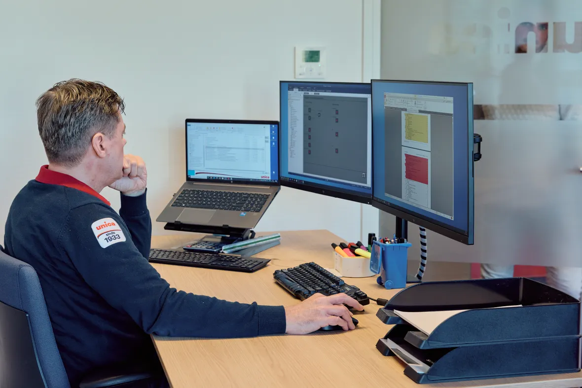 Medewerker van Unica kijkt geconcentreerd naar beeldscherm om systemen te monitoren