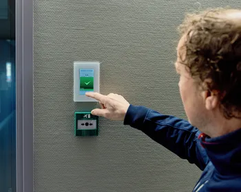 Medewerker van Unica bedient een touchpanel aan een technische installatie en checkt de status